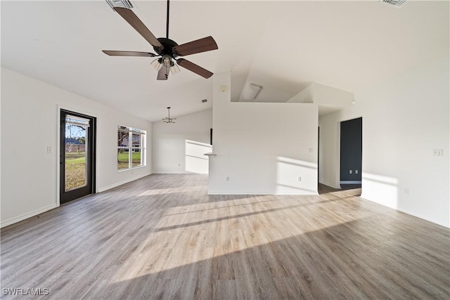 unfurnished living room with ceiling fan with notable chandelier, high vaulted ceiling, and light wood-type flooring