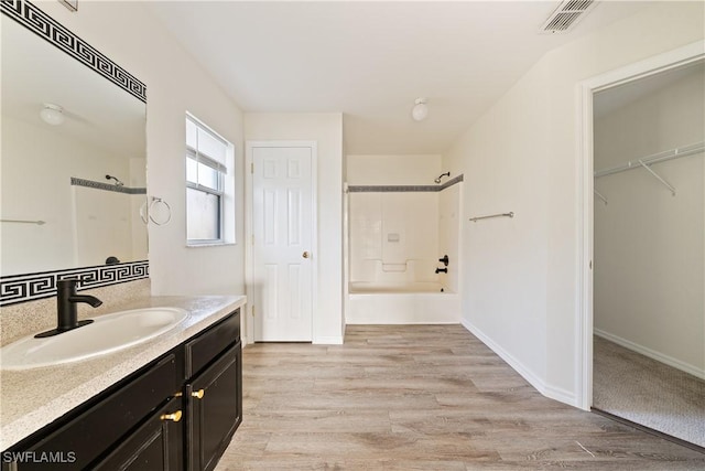 bathroom featuring vanity, hardwood / wood-style flooring, and shower / bathing tub combination