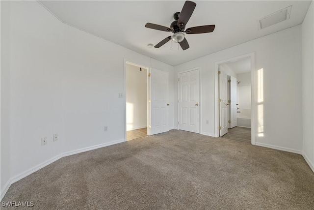 unfurnished bedroom with ceiling fan, light colored carpet, and connected bathroom