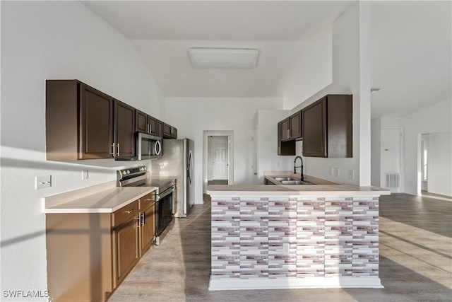 kitchen featuring stainless steel appliances, light hardwood / wood-style floors, sink, and dark brown cabinets