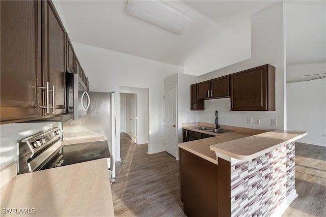 kitchen with dark brown cabinetry, sink, appliances with stainless steel finishes, kitchen peninsula, and light hardwood / wood-style floors