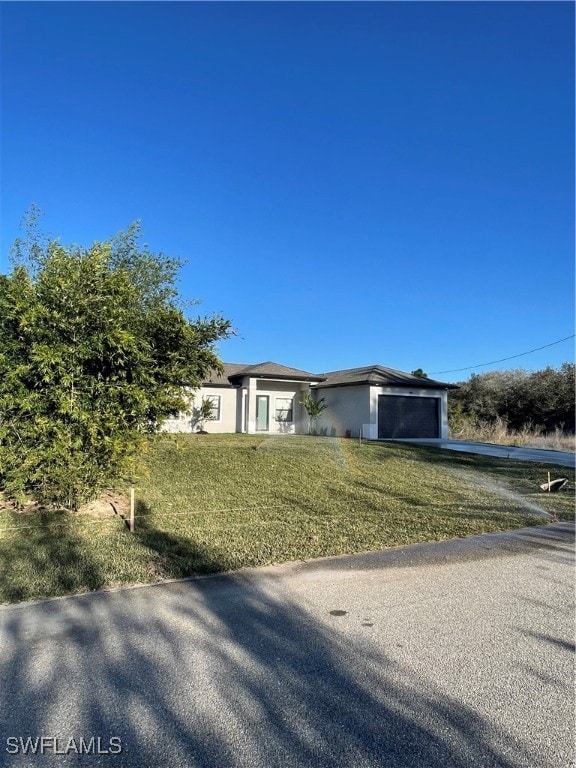 view of front of home featuring a garage and a front lawn