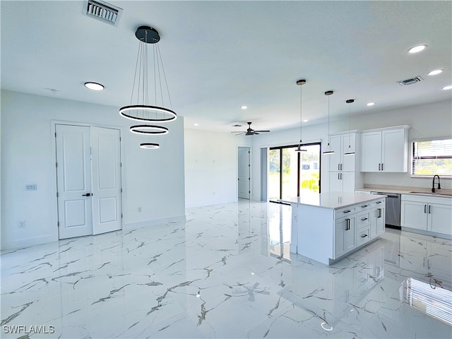 kitchen with stainless steel dishwasher, white cabinetry, and light tile patterned floors