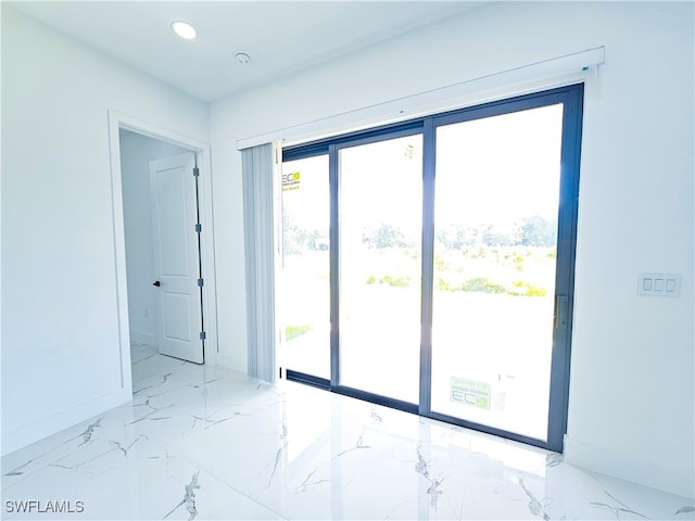 spare room featuring light tile patterned flooring and a healthy amount of sunlight