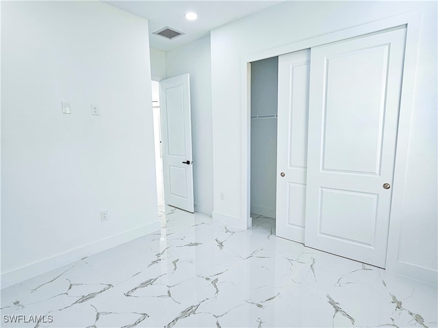 unfurnished bedroom featuring a closet and light tile patterned flooring