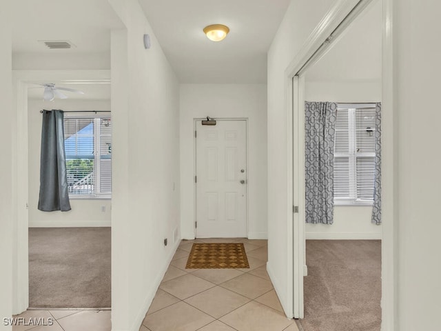 entrance foyer with ceiling fan and light colored carpet