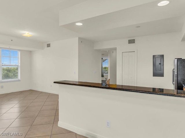 kitchen with light tile patterned floors, electric panel, and stainless steel refrigerator