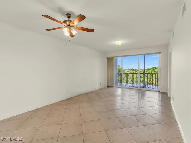 empty room with ceiling fan and light tile patterned floors