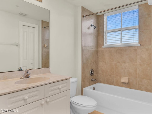 full bathroom featuring tiled shower / bath combo, vanity, and toilet