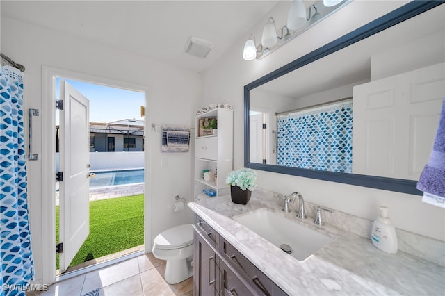 bathroom featuring plenty of natural light, vanity, tile patterned flooring, and toilet