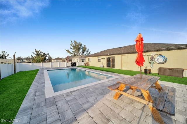 view of swimming pool with a patio area and a yard