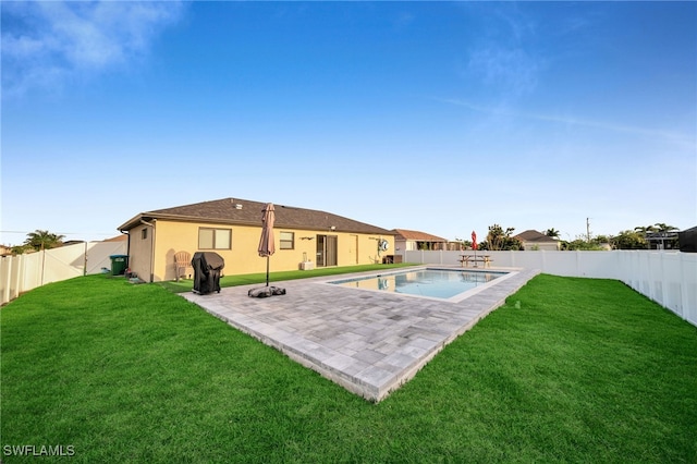 back of property featuring a patio area, a fenced in pool, and a lawn