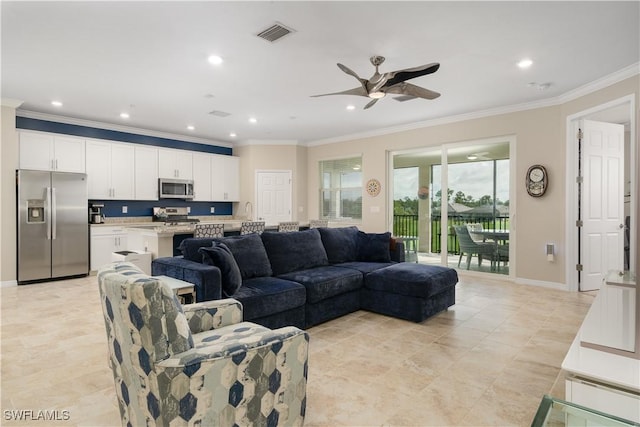 living room with ceiling fan, crown molding, and sink