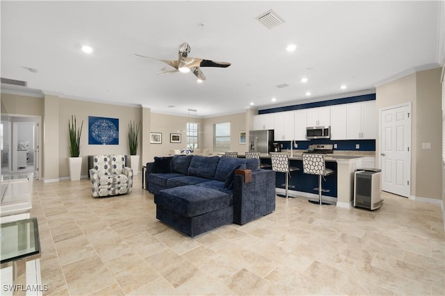 living room featuring ceiling fan and ornamental molding