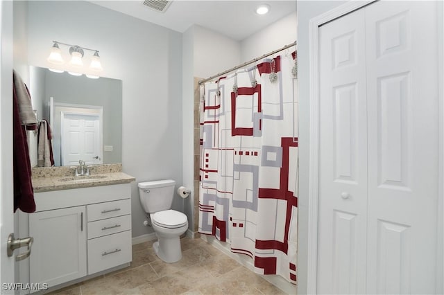 bathroom featuring visible vents, a shower with shower curtain, toilet, vanity, and a closet