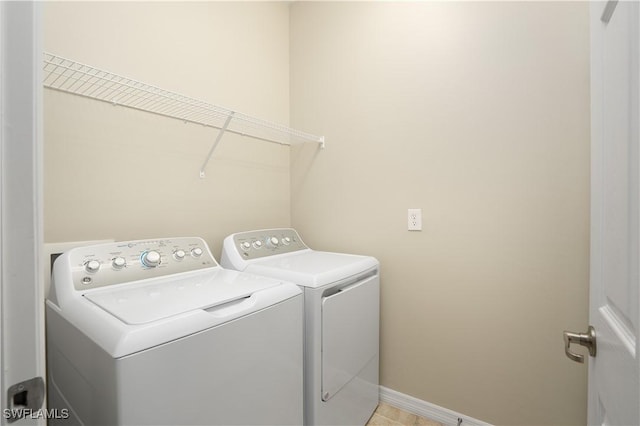 clothes washing area featuring laundry area, independent washer and dryer, and baseboards