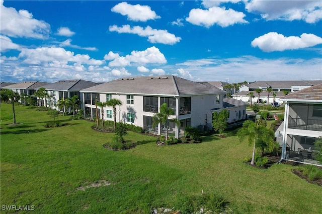 back of house with a residential view and a yard