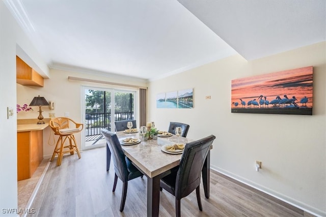 dining area featuring hardwood / wood-style flooring and crown molding