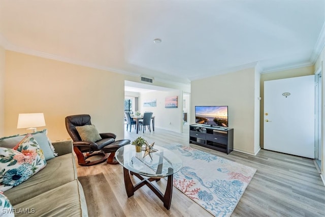 living room featuring light hardwood / wood-style floors and ornamental molding