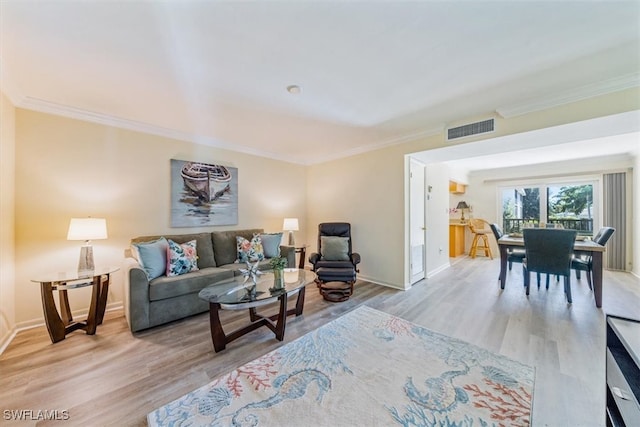 living room with crown molding and light hardwood / wood-style flooring