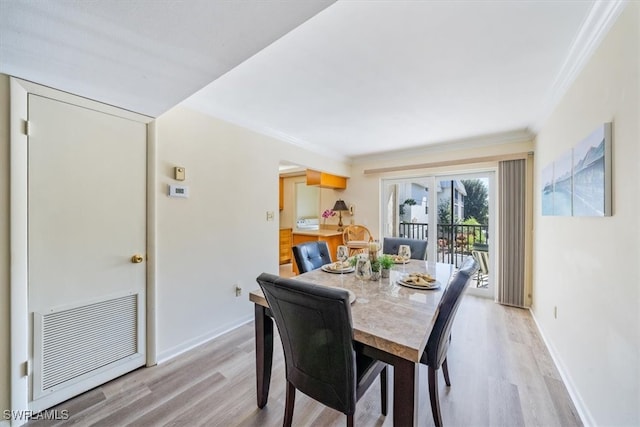 dining area featuring crown molding and light hardwood / wood-style flooring