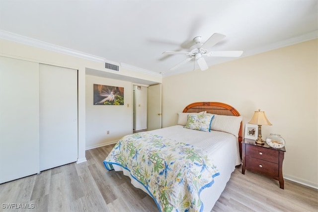 bedroom with a closet, crown molding, light wood-type flooring, and ceiling fan