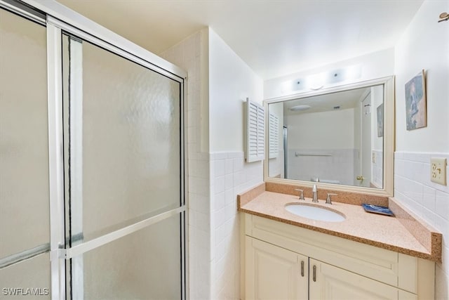 bathroom featuring tile walls, vanity, and an enclosed shower