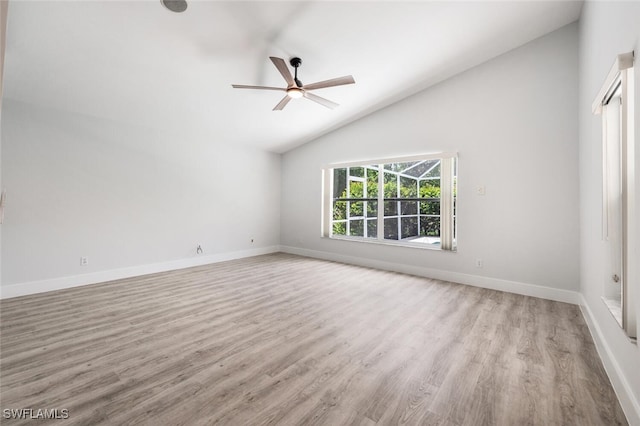 spare room with high vaulted ceiling, wood finished floors, a ceiling fan, and baseboards