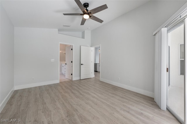 unfurnished bedroom featuring high vaulted ceiling, light wood-type flooring, ceiling fan, and connected bathroom