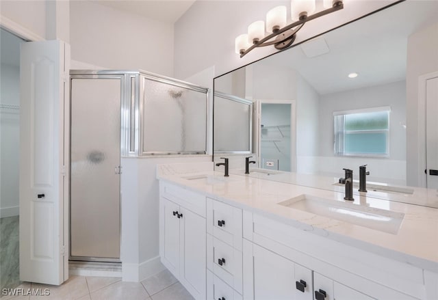 bathroom with a shower with door, tile patterned flooring, and double vanity