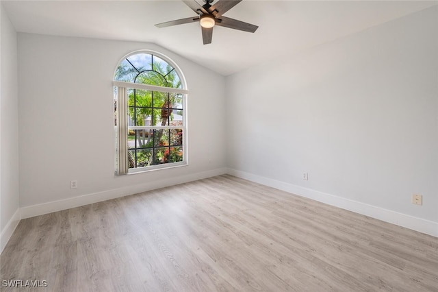 unfurnished room featuring light wood-type flooring, vaulted ceiling, and a healthy amount of sunlight