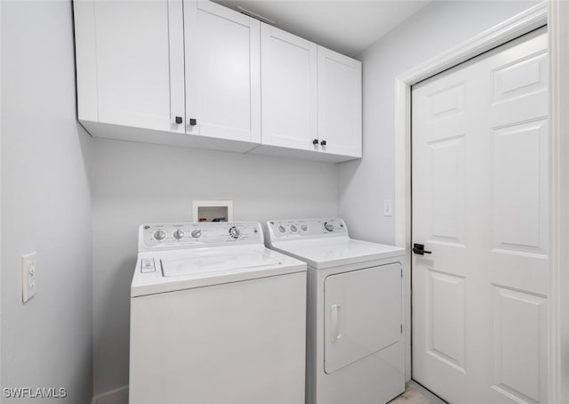 washroom featuring washing machine and clothes dryer and cabinets