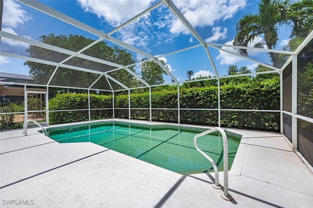 view of pool with a patio and glass enclosure