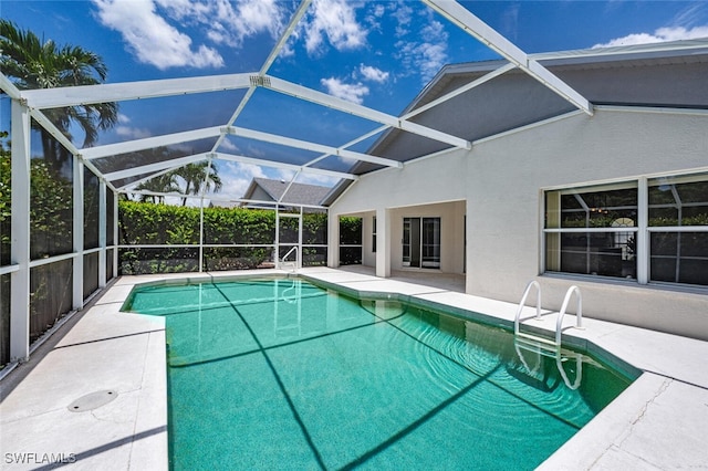 view of swimming pool featuring a patio area and glass enclosure