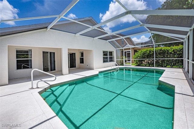 view of pool with glass enclosure and a patio area