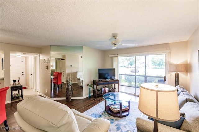 living area featuring wood finished floors, ceiling fan, a textured ceiling, and baseboards