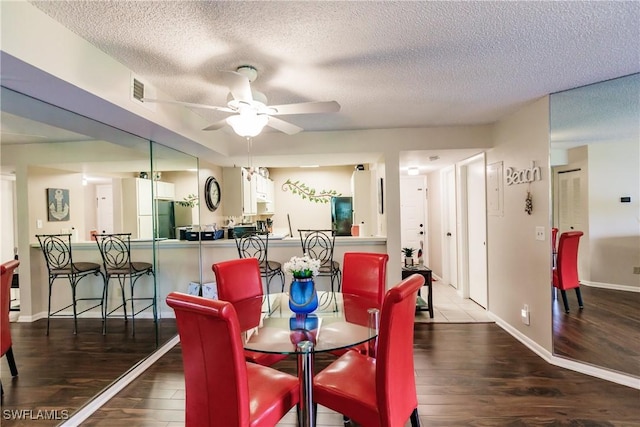 dining room with ceiling fan, wood finished floors, a textured ceiling, and baseboards