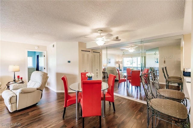 dining space featuring a textured ceiling, wood finished floors, baseboards, and a ceiling fan