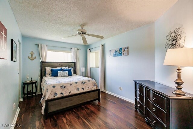 bedroom featuring wood finished floors, baseboards, a textured ceiling, and a ceiling fan