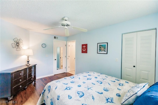 bedroom with a closet, wood finished floors, a textured ceiling, baseboards, and a ceiling fan