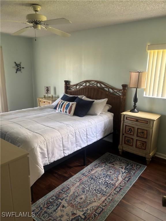 bedroom featuring wood finished floors, a textured ceiling, and ceiling fan