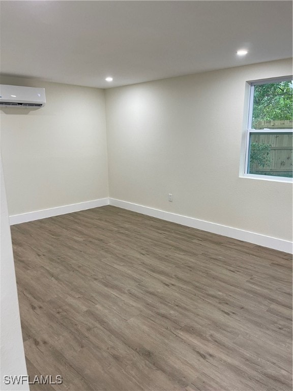 empty room with hardwood / wood-style flooring and a wall mounted air conditioner