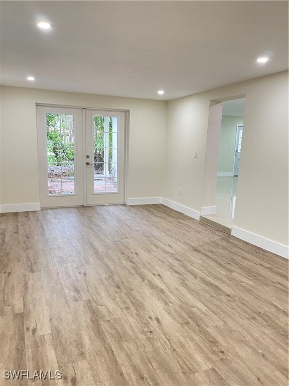 unfurnished room with french doors and light hardwood / wood-style floors