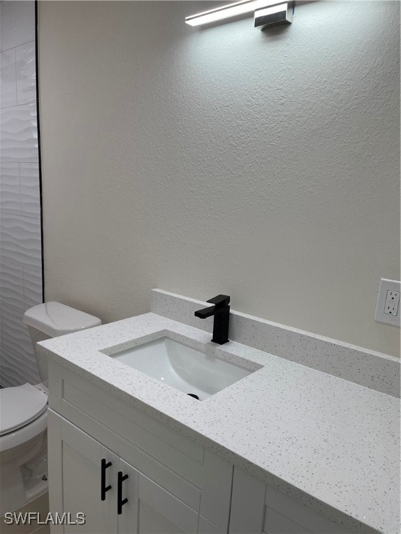 bathroom featuring toilet and vanity