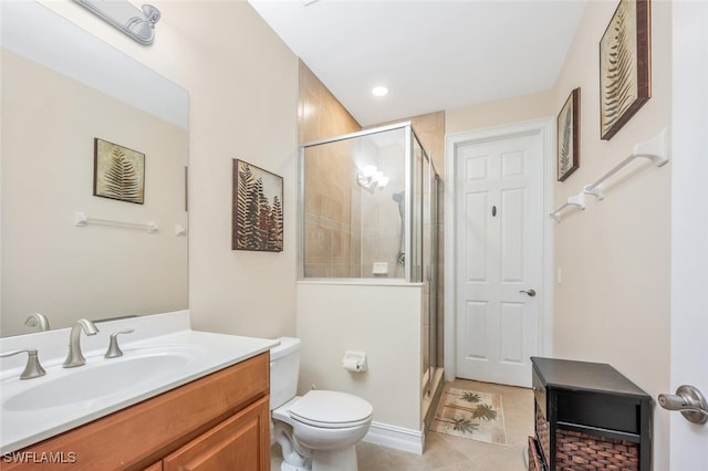 bathroom featuring tile patterned floors, vanity, toilet, and a shower with door