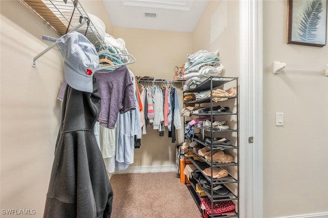 walk in closet with carpet