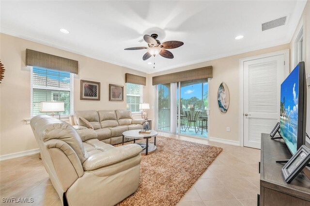 tiled living room with ceiling fan and crown molding