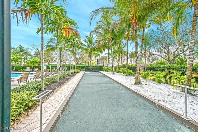 surrounding community featuring a game area, a pool, and fence