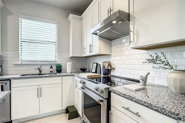 kitchen featuring appliances with stainless steel finishes, tasteful backsplash, light stone counters, and white cabinetry