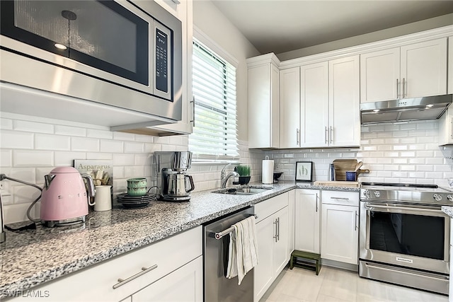 kitchen with sink, white cabinetry, backsplash, and stainless steel appliances